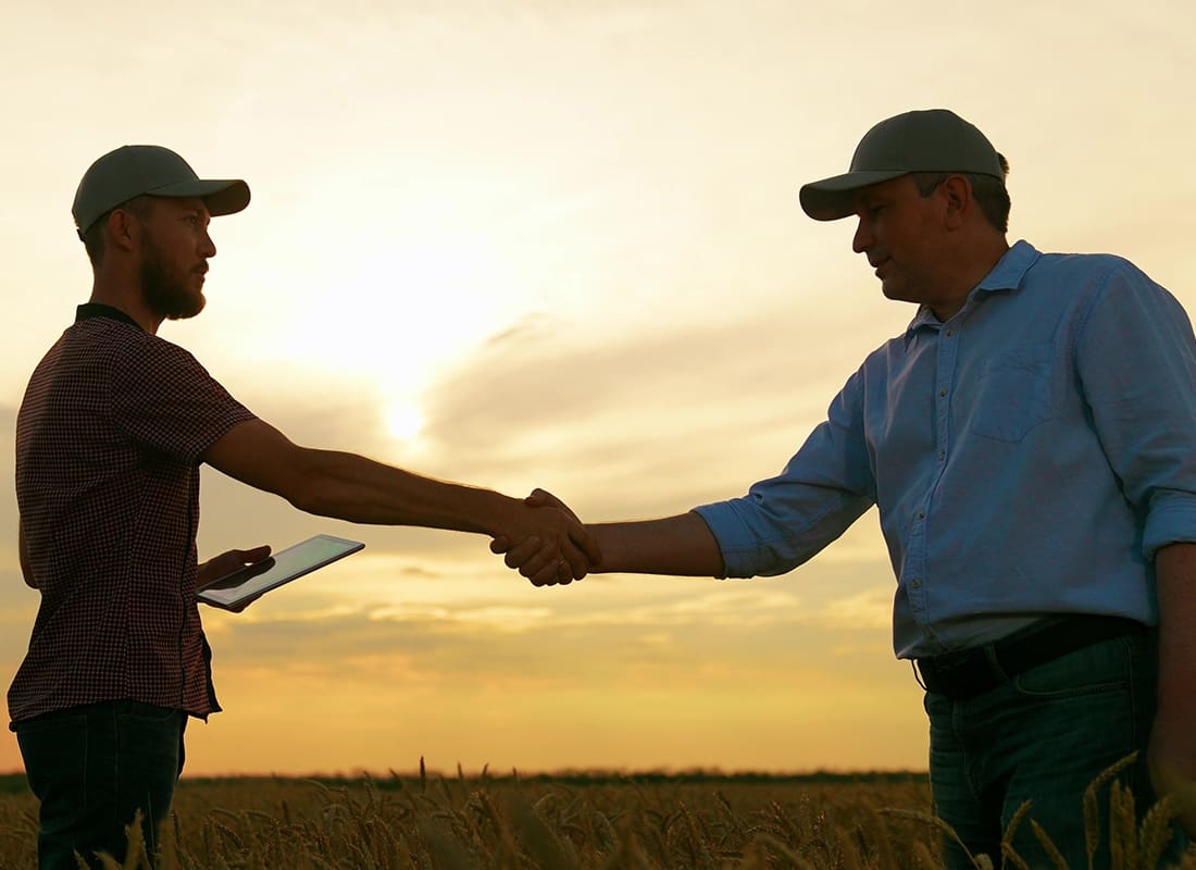 Personal Insurance - Farmer Shaking Hands With an Agent on His Farm